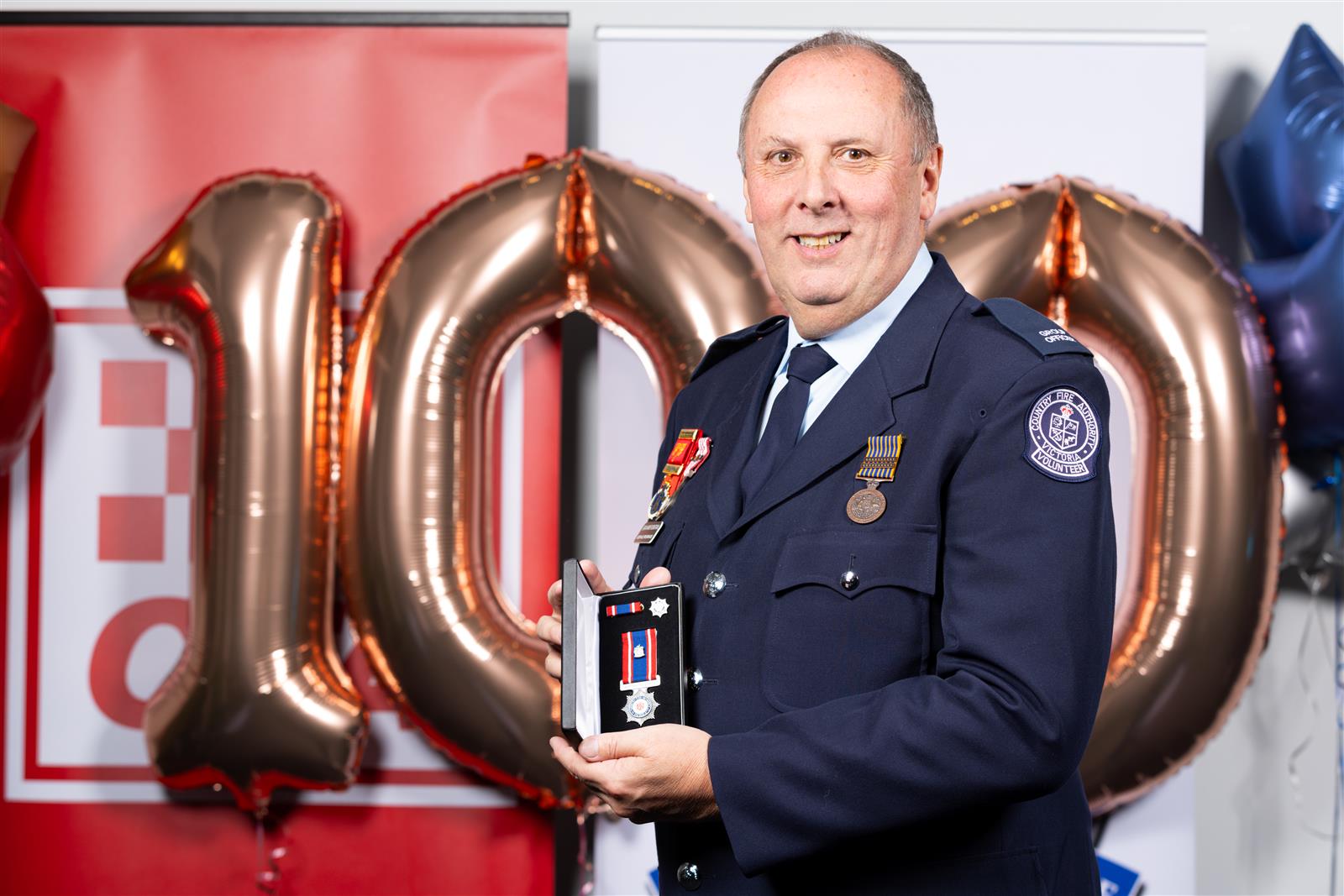 Graham Fountain holding his Outstanding Service Medal