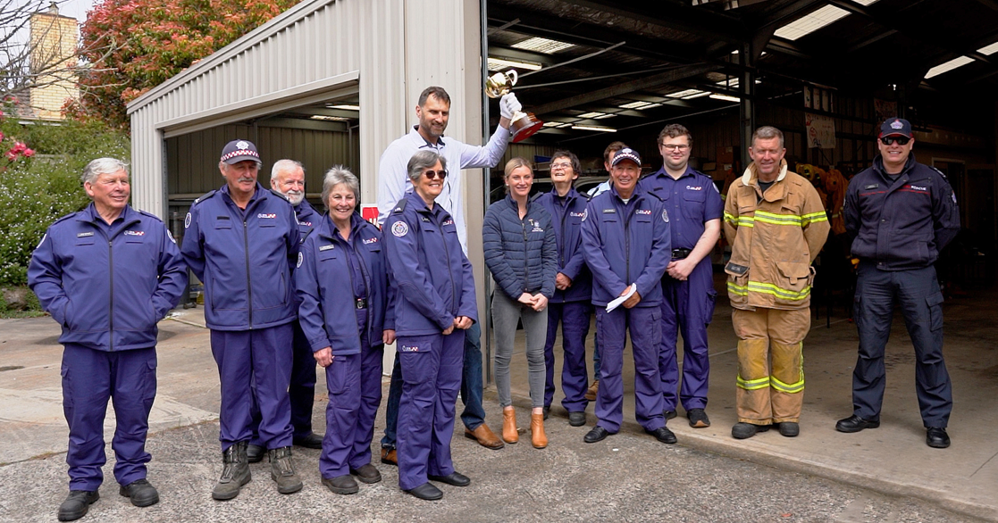 Jockey Jamie Kah, former Australian Basketballer Chris Anstey and members of the Trentham Fire Brigade pose with the Melbourne Cup